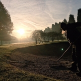 Greenkeeper raking a bunker